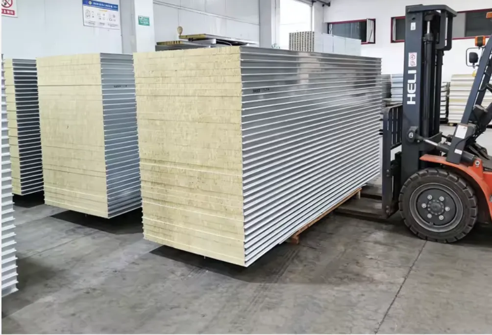 Large stack of insulated back pan assemblies with light-colored infill cores in the fabrication shop