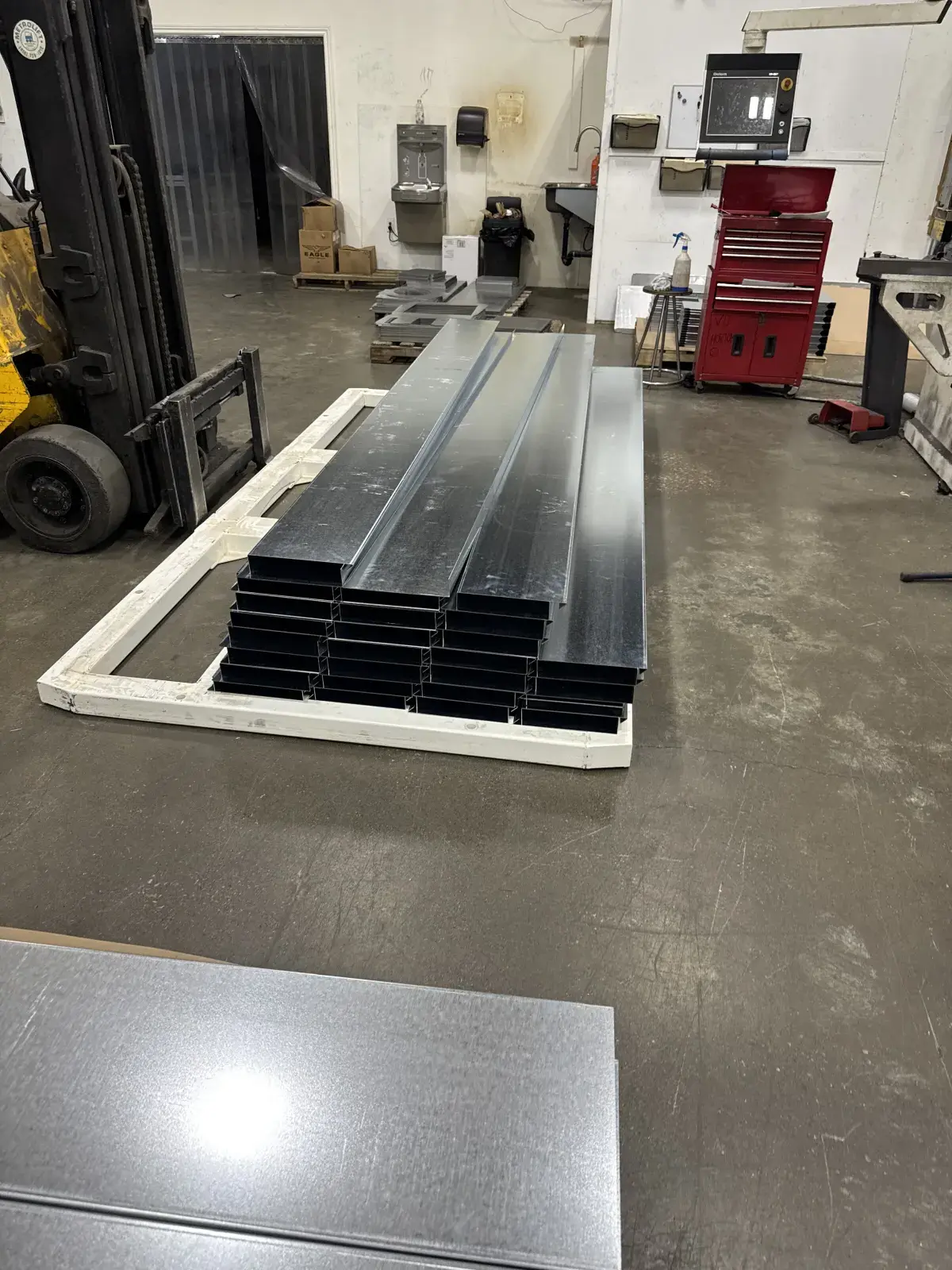 Curved and rectangular head and jamb closure assemblies laid out on a shop floor