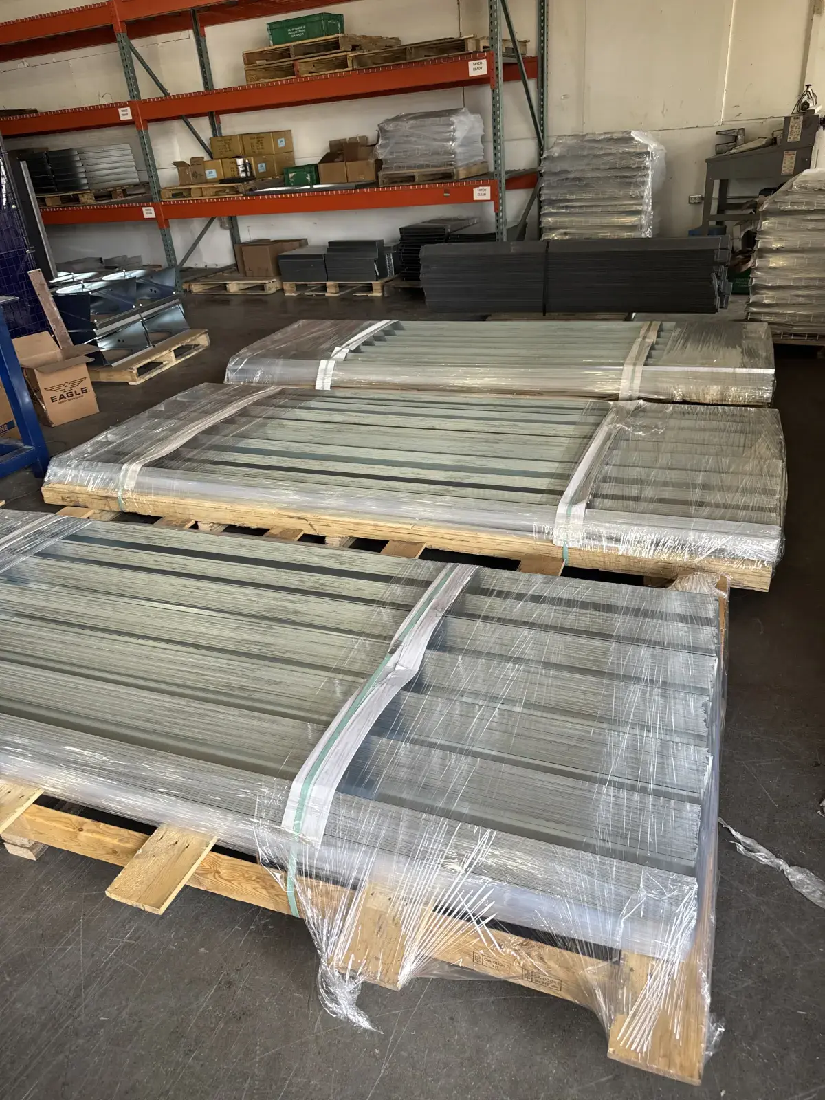 Wrapped perimeter trim and slab-edge closure parts staged on pallets in the shop