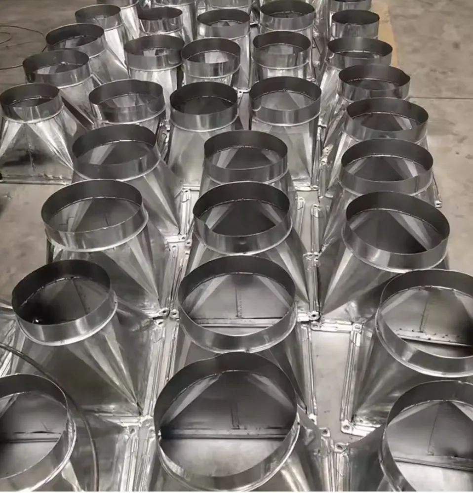 Rectangular duct transitions and offset-style fabricated parts laid out on a shop floor