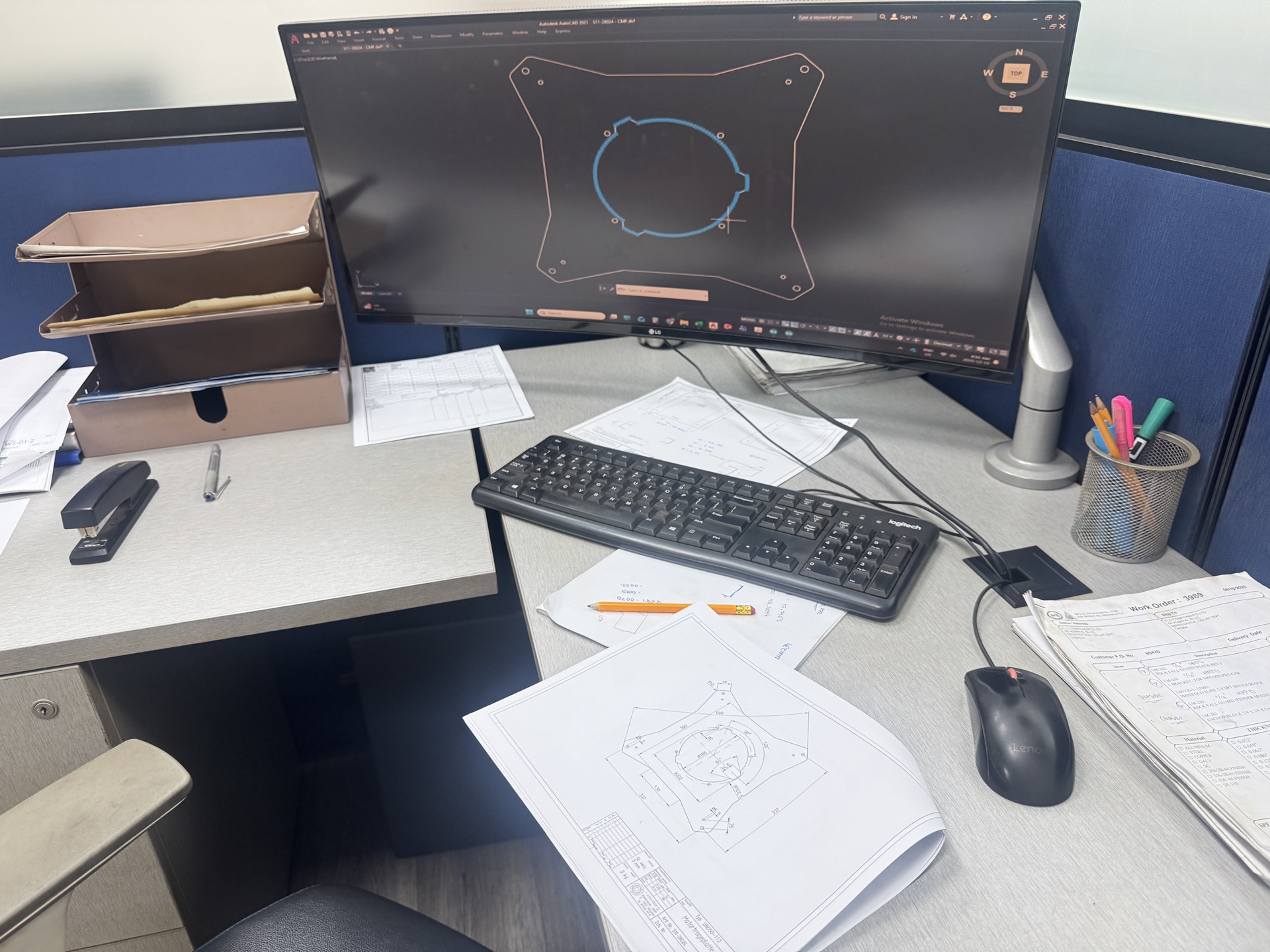 CAD workstation with AutoCAD displaying sheet metal part design and technical drawings